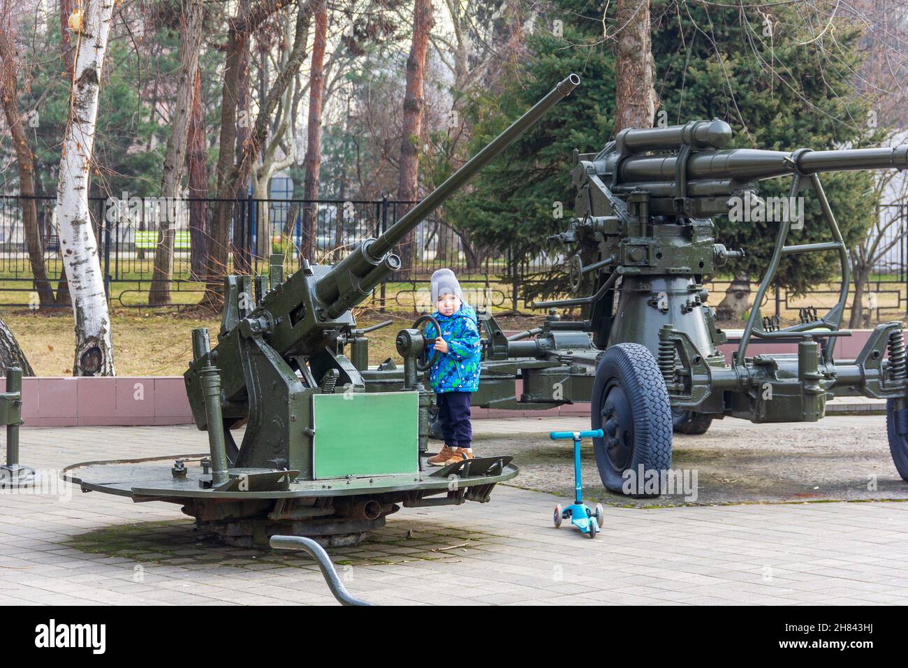 un ragazzino gioca nel parco con una pistola antiaerea Foto Stock