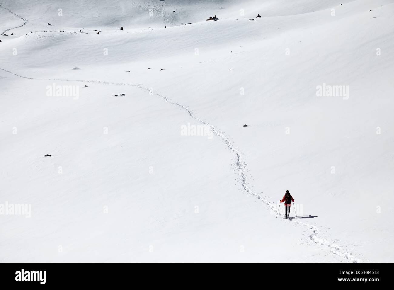 Uomo con zaino che cammina sulla collina della neve con le impronte ad Almaty, Kazakhstan Foto Stock