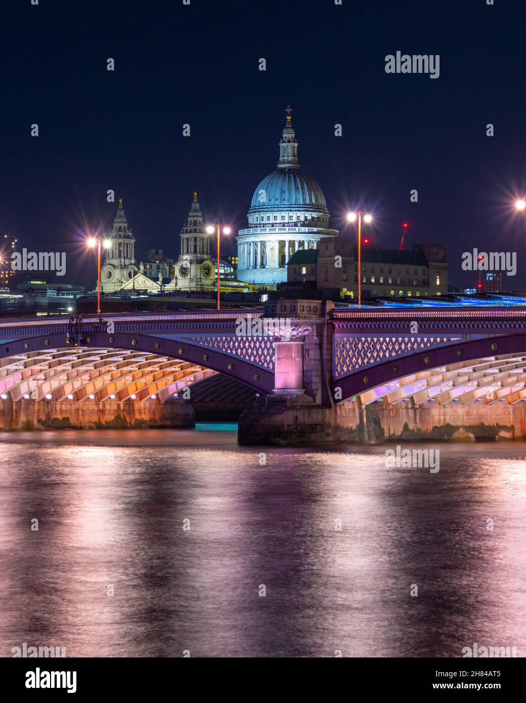 La cattedrale di St Paul di notte con il fiume tamigi in primo piano e la stazione dei Blackfriars che corre lungo il ponte in primo piano. Foto Stock