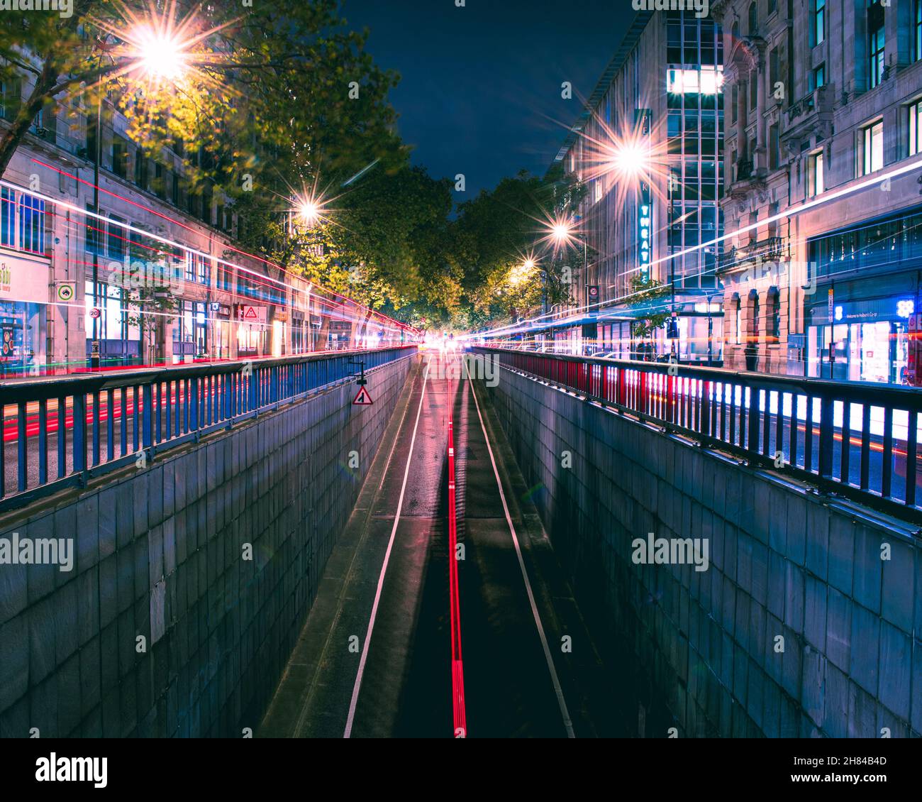 I veicoli si trovano su entrambi i lati della strada mentre i veicoli escono dal sottopasso di Holborn a Londra. Bellissimi sentieri luminosi. Foto Stock
