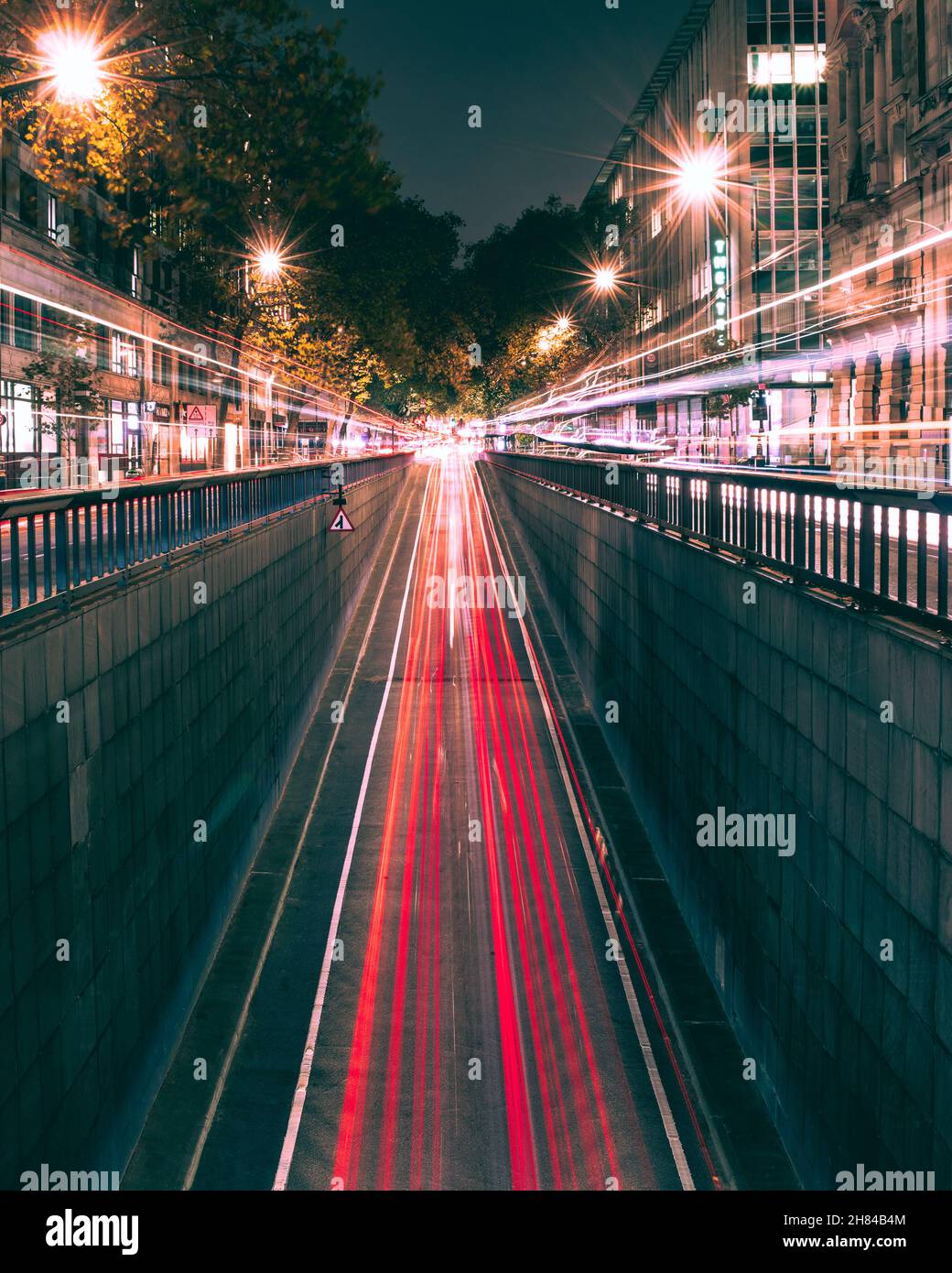 I veicoli si trovano su entrambi i lati della strada mentre i veicoli escono dal sottopasso di Holborn a Londra. Bellissimi sentieri luminosi. Foto Stock