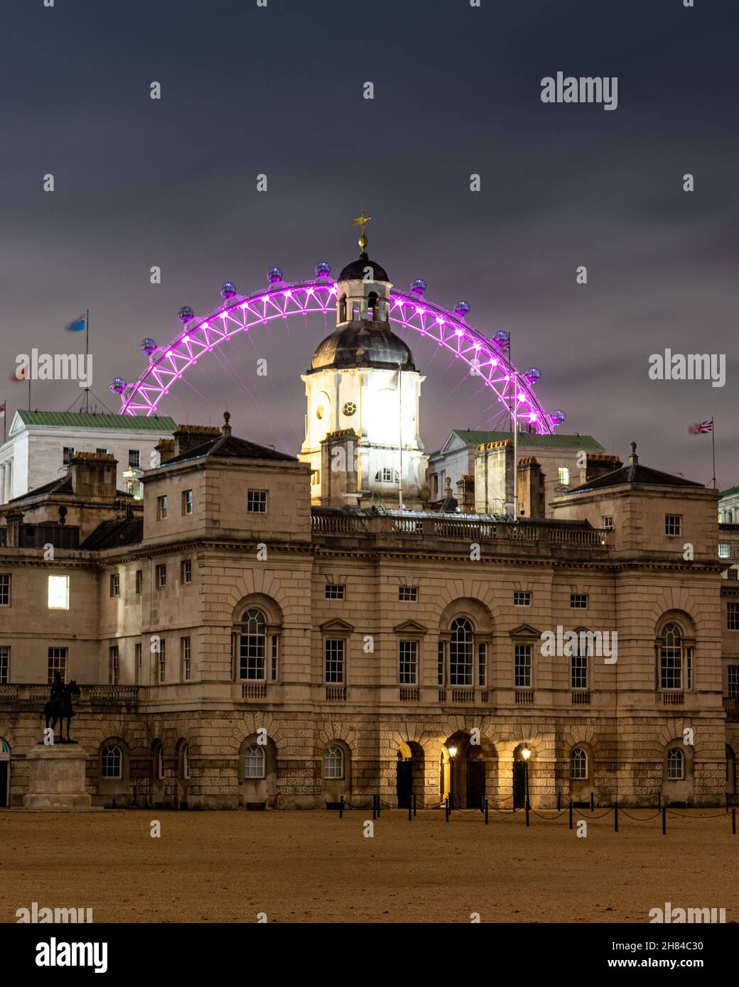 Una lunga esposizione notturna cattura di guardie di cavalli sfilata a Londra con il lastminute.com London Eye sullo sfondo Foto Stock