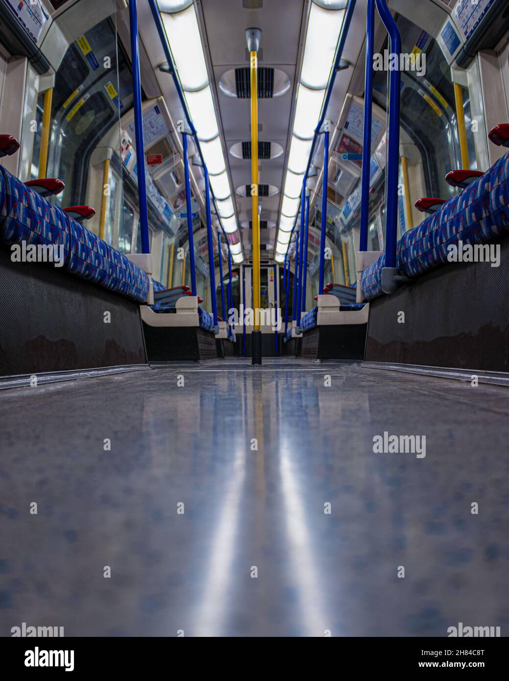 Un colpo ad angolo basso che mostra l'interno di una carrozza di Piccadilly Line che viaggia in direzione nord sulla metropolitana di Londra. Foto Stock