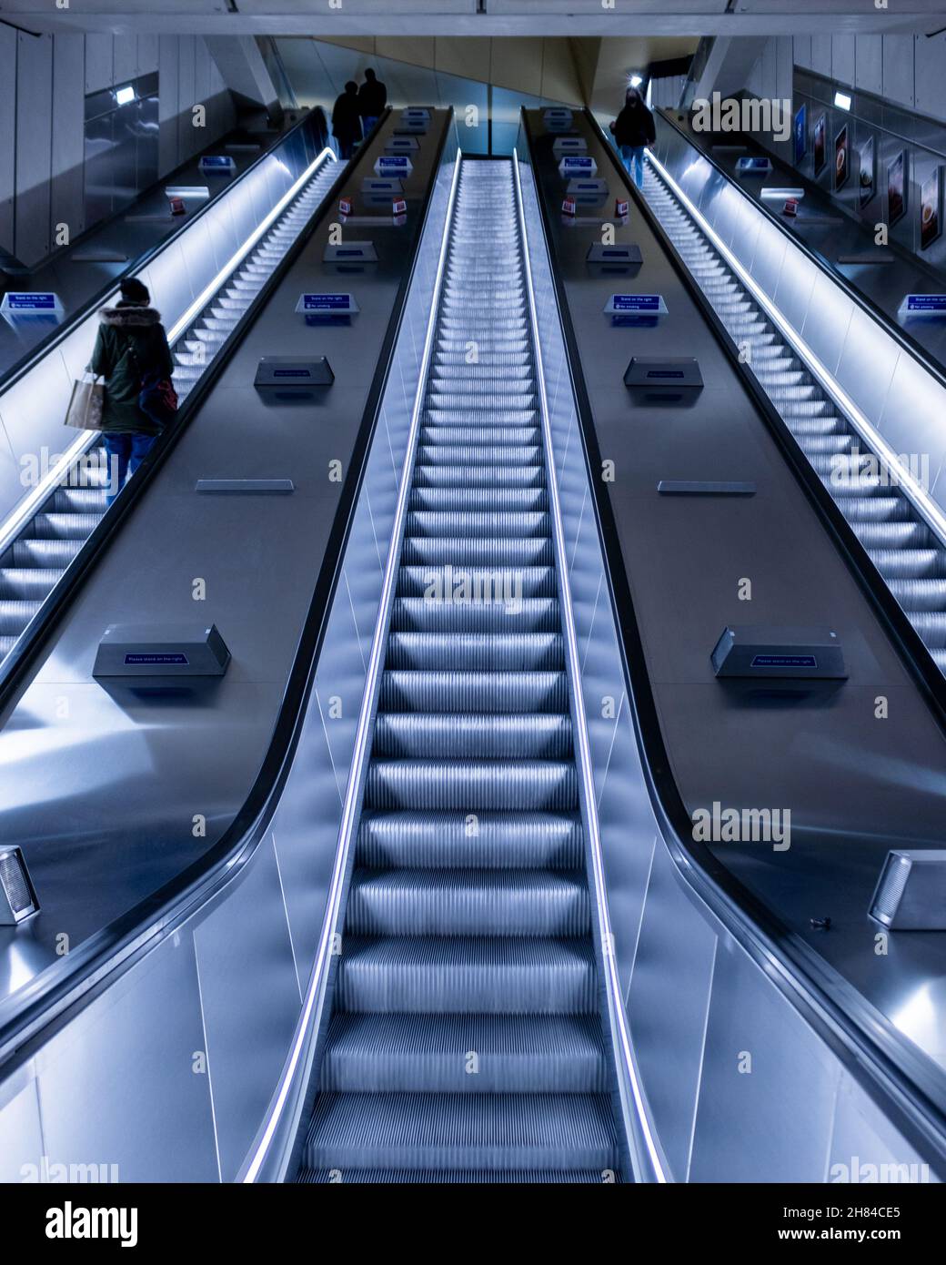 Persone che viaggiano sulle scale mobili della stazione della metropolitana di Battersea Power Station sulla rete della metropolitana di Londra di notte sull'estensione della linea nord Foto Stock