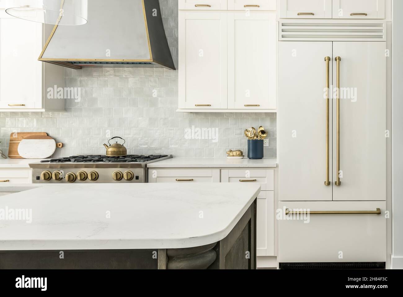 Cucina moderna bianca con shaker Cabinets, contatori di granito, backsplash grigio, e moderno Appliances Interior Design Foto Stock