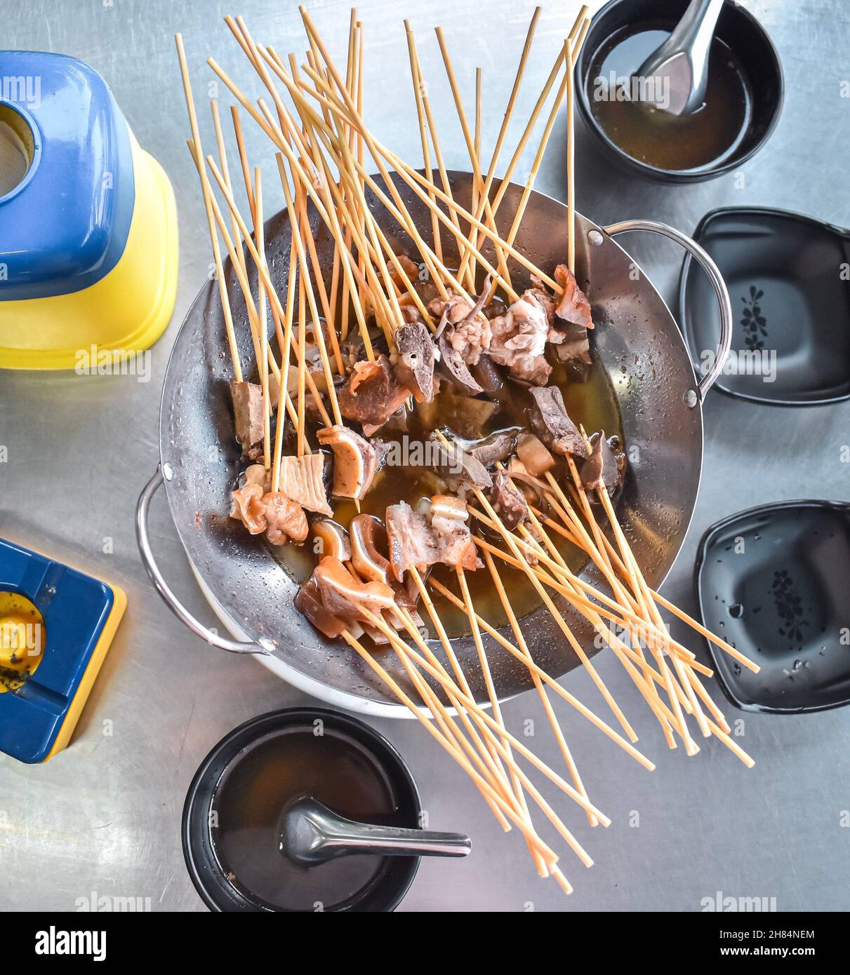 Carni di varietà di maiale bollite su bastoni di bambù. Famoso Myanmar Street food Foto Stock