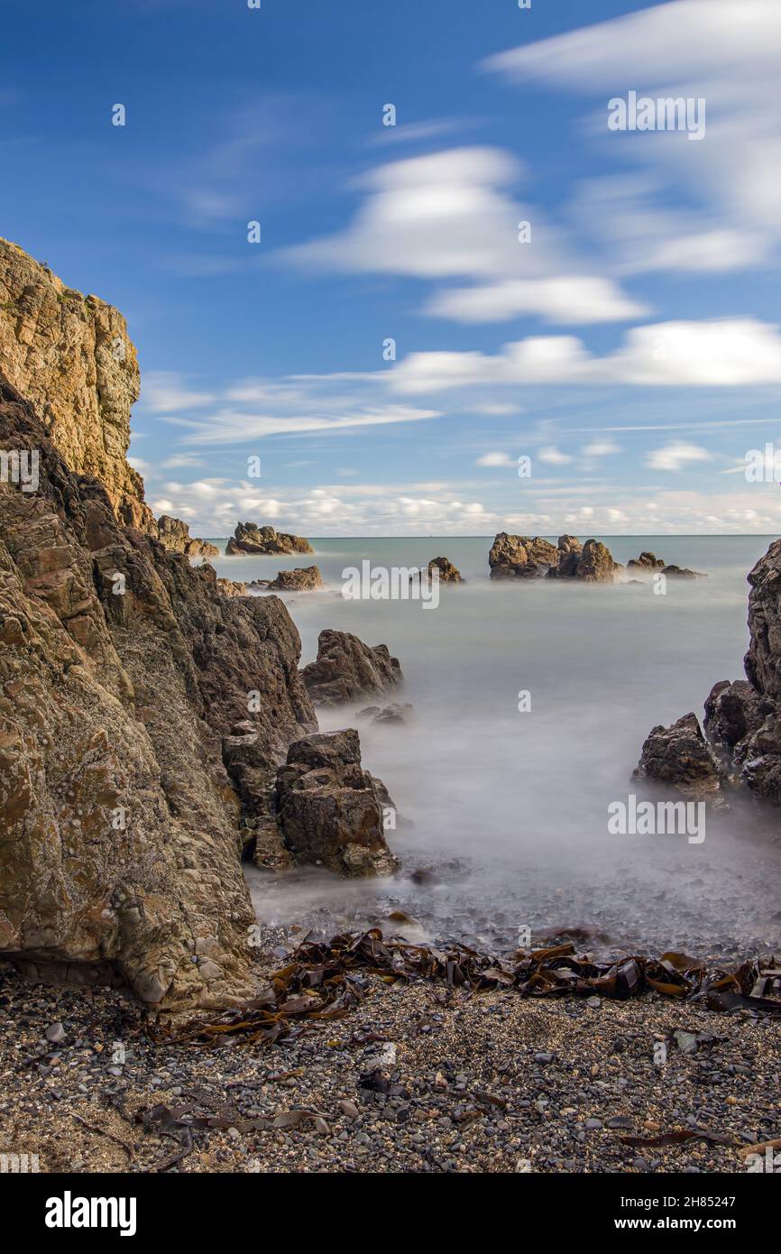 La penisola di Howth Head in giornata soleggiata e nuvolosa, esposizione a lungo, Dublino County, Seashore di scogliere, baie e rocce paesaggio, Irlanda Foto Stock
