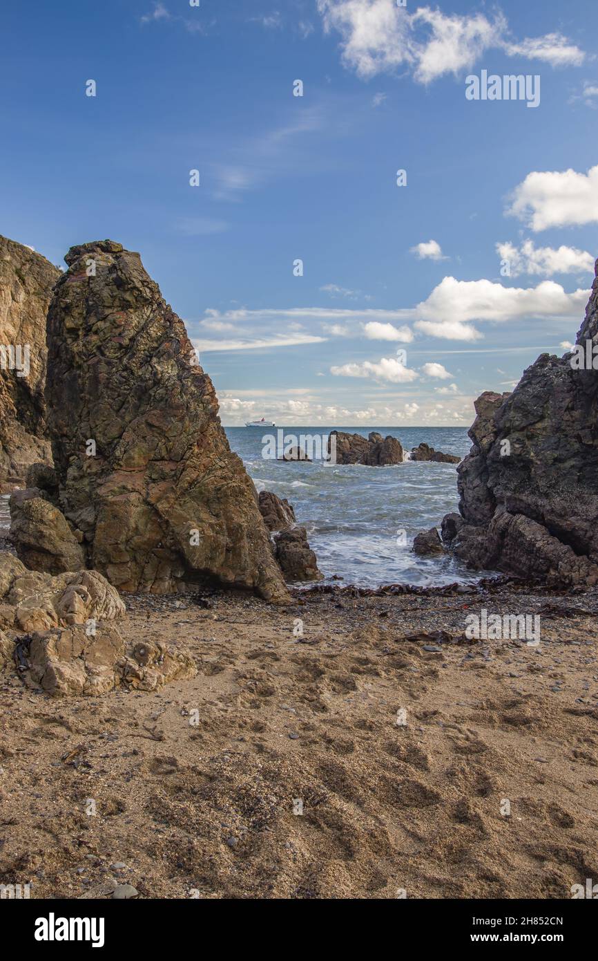 La penisola di Howth Head in giornata soleggiata e nuvolosa, baia nascosta, cielo drammatico, contea di Dublino, Seashore di scogliere, Baie e rocce paesaggio, Irlanda Foto Stock