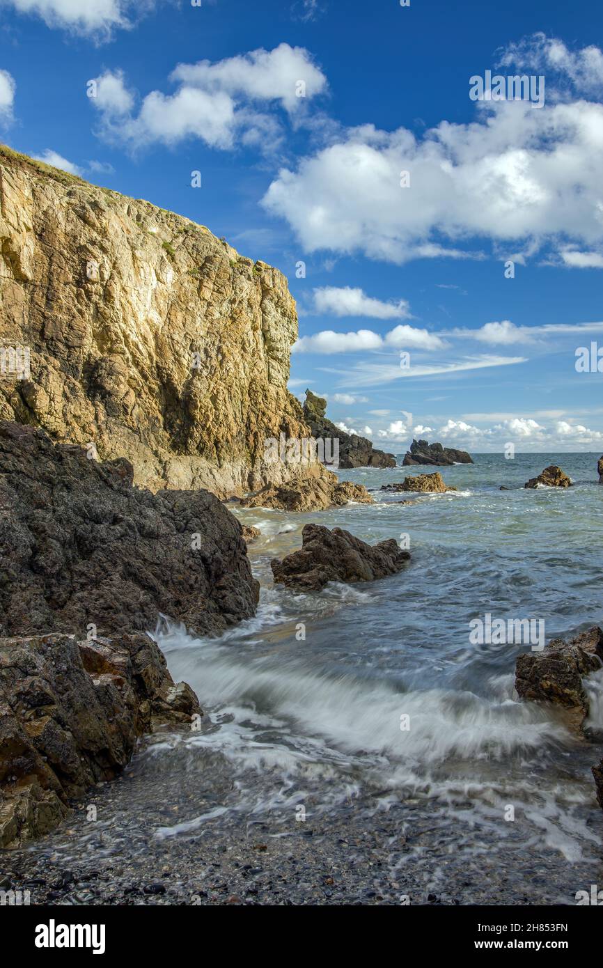La penisola di Howth Head in giornata soleggiata e nuvolosa, baia nascosta, cielo drammatico, contea di Dublino, Seashore di scogliere, Baie e rocce paesaggio, Irlanda Foto Stock
