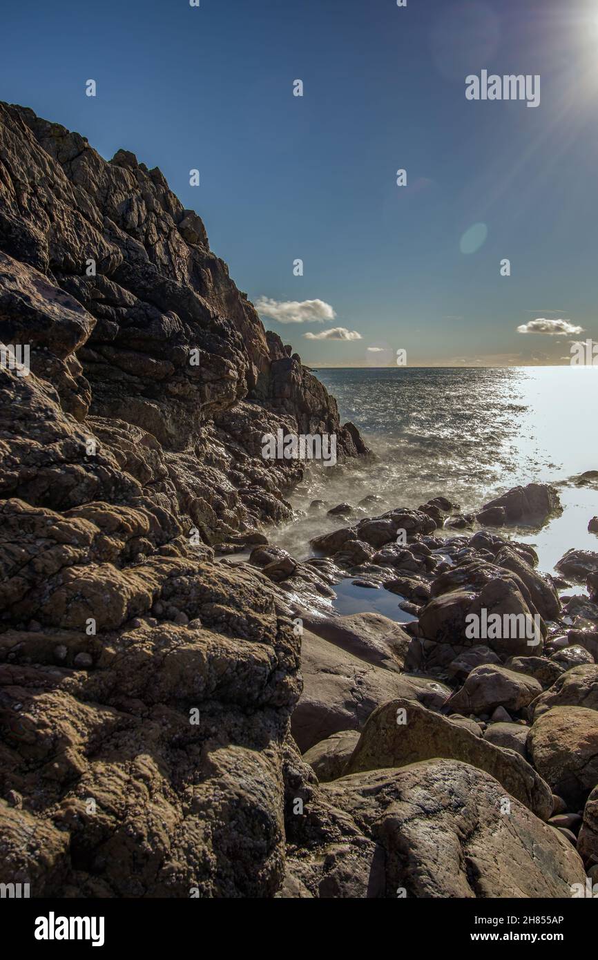 La penisola di Howth Head in giornata soleggiata e nuvolosa, esposizione a lungo, Dublino County, Seashore di scogliere, baie e rocce paesaggio, Irlanda Foto Stock
