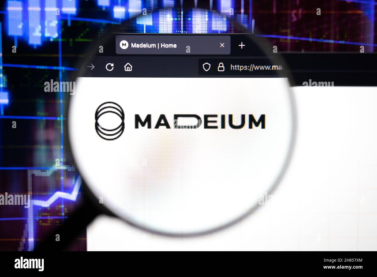 Logo aziendale Madeium su un sito web, visto su uno schermo del computer attraverso una lente d'ingrandimento. Foto Stock