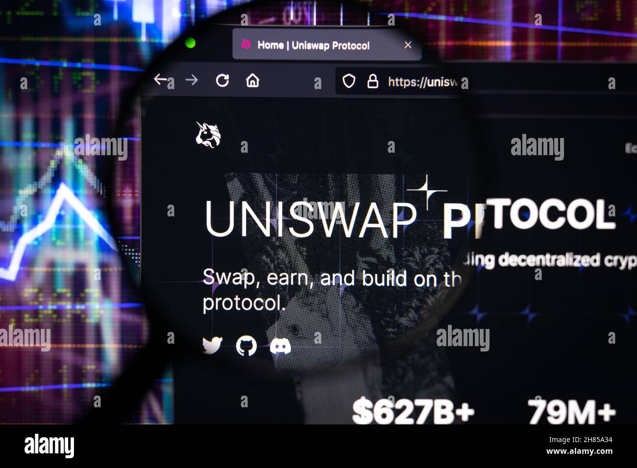 Uniswap logo aziendale di scambio criptovaluta decentralizzato su un sito web, visto su uno schermo del computer attraverso una lente d'ingrandimento. Foto Stock