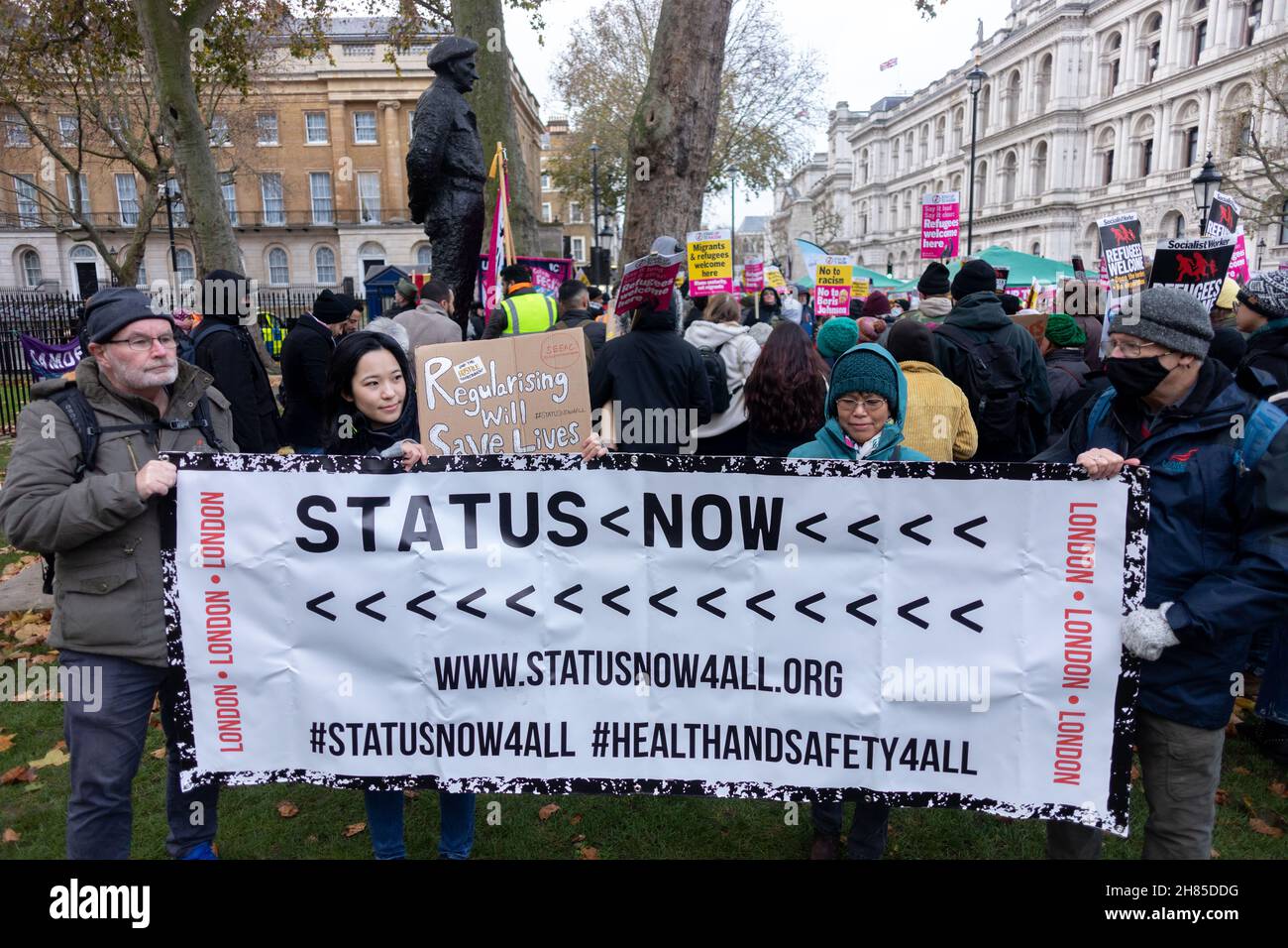 Londra, Regno Unito. 27 novembre 2021. I manifestanti hanno visto tenere una bandiera che dice lo status ora durante la dimostrazione.Stand Up to Racism UK organizzato una protesta contro la nazionalità e confini Bill introdotto dal governo Tory. Hanno invitato i Boris Johnson e Priti Patel ad aprire le porte a un maggior numero di migranti, alla luce di una recente annegazione di migranti in viaggio verso il Regno Unito. Credit: SOPA Images Limited/Alamy Live News Foto Stock