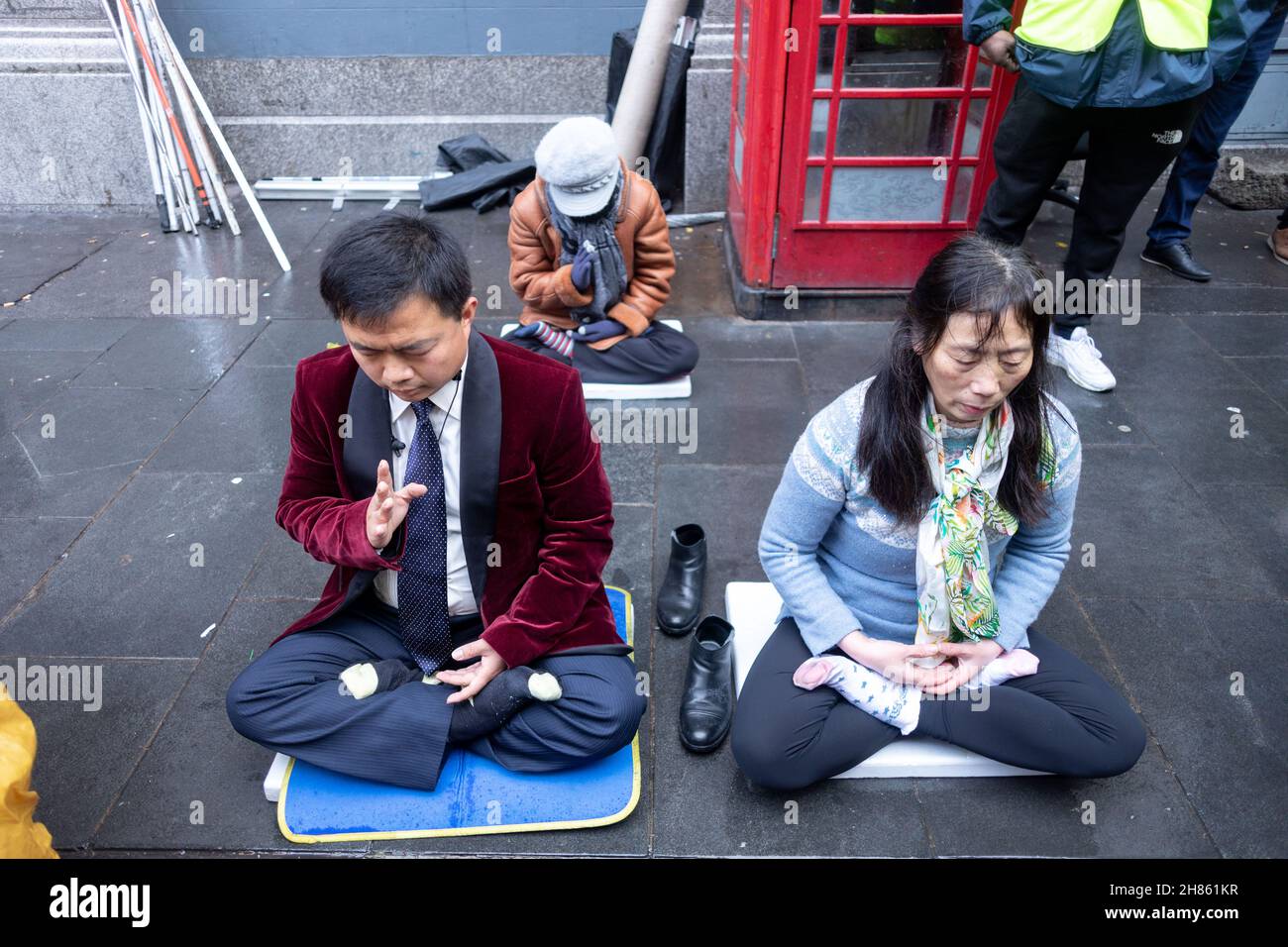 Londra, Regno Unito. 27 novembre 2021. I praticanti di Falun Gong hanno visto meditare accanto al rally.congiuntamente organizzato da Friends of Socialist China, min Quan Legal Center e il gruppo di monitoraggio, a China Town, il rally è stato tenuto per aumentare la consapevolezza contro l'odio verso gli asiatici. Durante il raduno, Hong Kongers si riunì per protestare contro il regime del Pcc. Credit: SOPA Images Limited/Alamy Live News Foto Stock