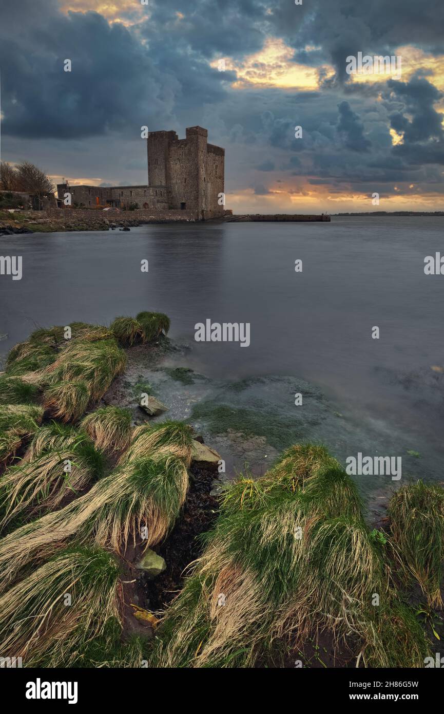 Spettacolare tramonto nuvoloso del Castello di Oranmore sulla costa rocciosa di Wild atlantic Way nella contea di Galway, Irlanda Foto Stock
