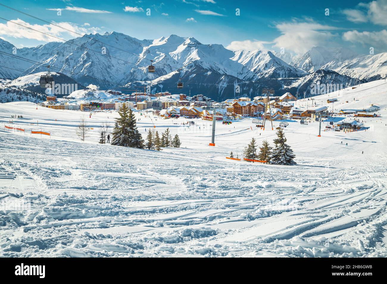 Piste da sci sulle fresche e profonde colline innevate. Stazione sciistica alpina con sciatori e funivie, Alpe d Huez, Francia, Europa Foto Stock