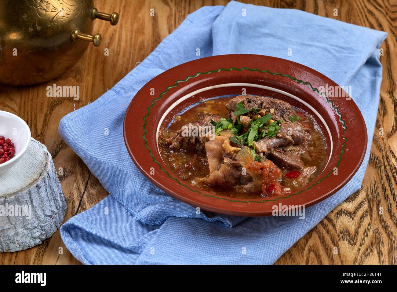 Buglama azerbaigiana, su un piatto bianco con erbe e salsa Foto Stock