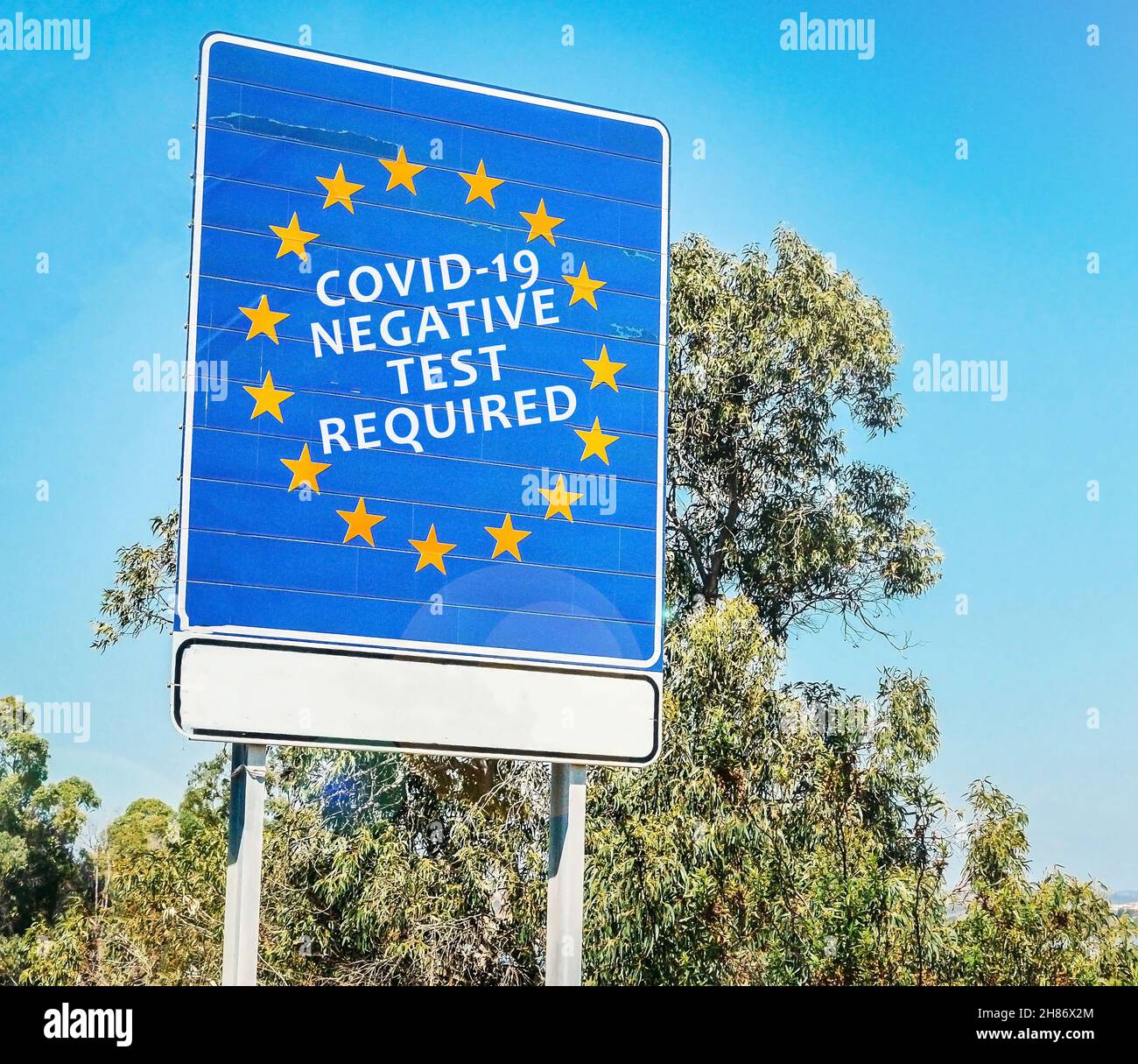 Bandiera dell'Unione europea con messaggio che richiede un test negativo del Covid-19 per attraversare la frontiera terrestre Foto Stock