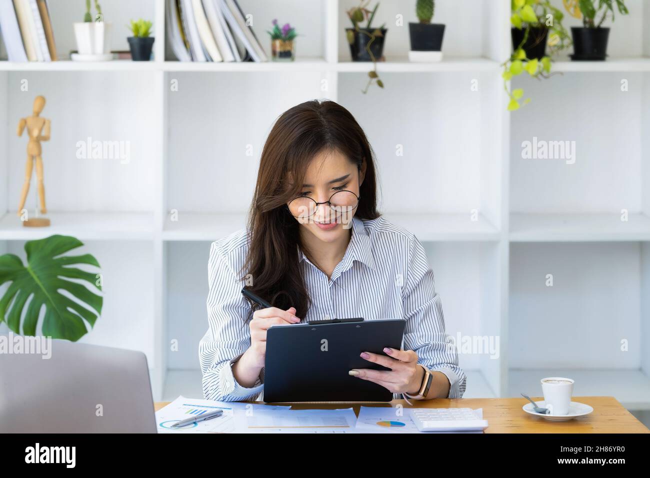 Lavoro da casa. Avviare un proprietario di piccola impresa utilizzando penne e documenti, il reddito aziendale personale e computer per lavorare. Foto Stock