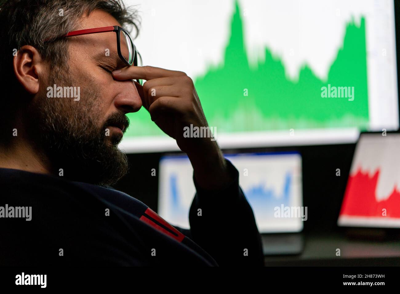 Uomo d'affari depresso di fronte al computer con grafico di affari falliti sullo schermo. Foto di alta qualità. Foto Stock