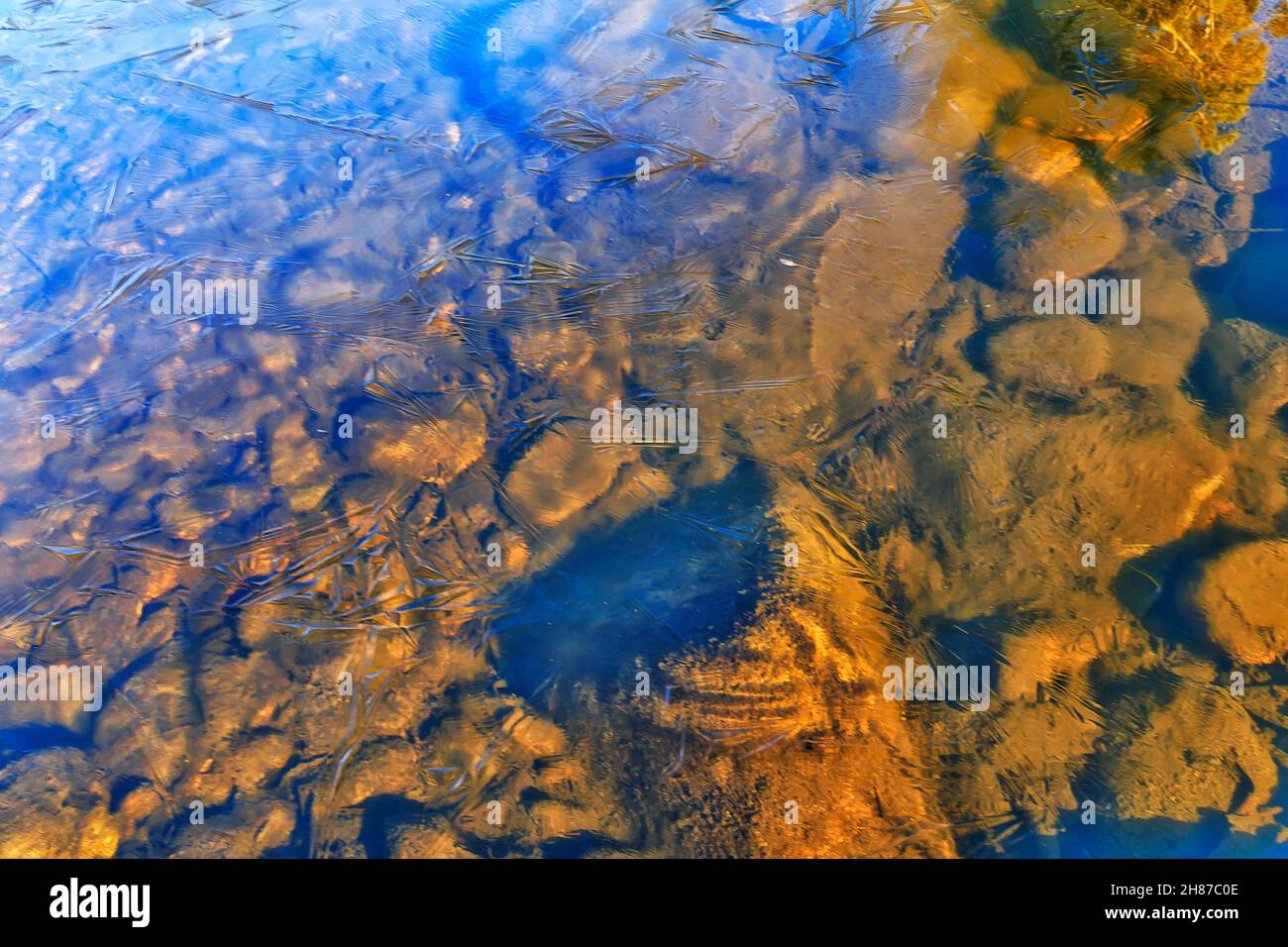 Fondale roccioso di Snowy River coperto da sottile ghiaccio traslucido in alta stagione invernale nelle Snowy Mountains d'Australia. Foto Stock