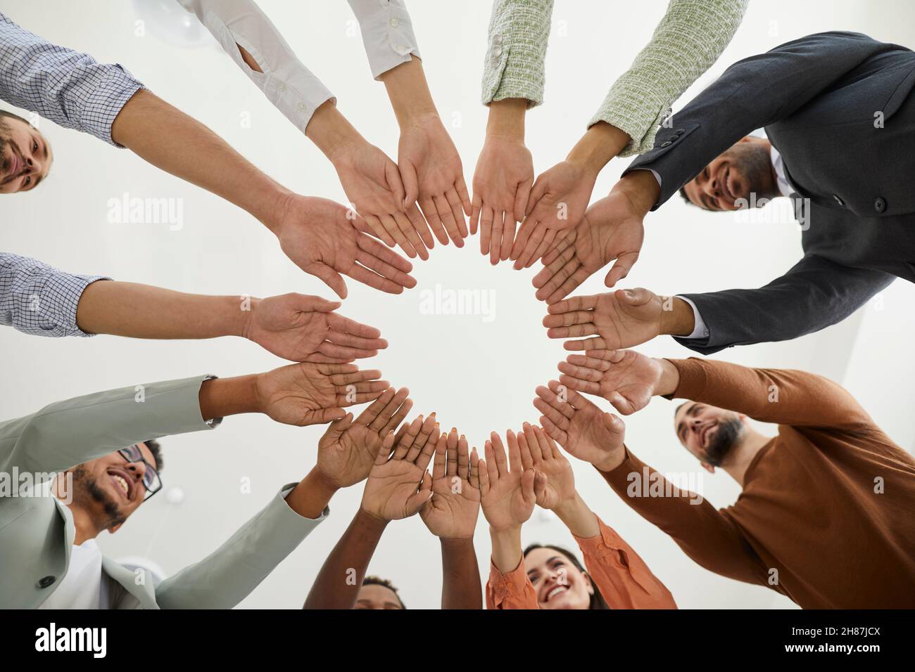 Team di persone felici e diverse che si uniscono per mostrare il concetto di comunità e lavoro di squadra Foto Stock