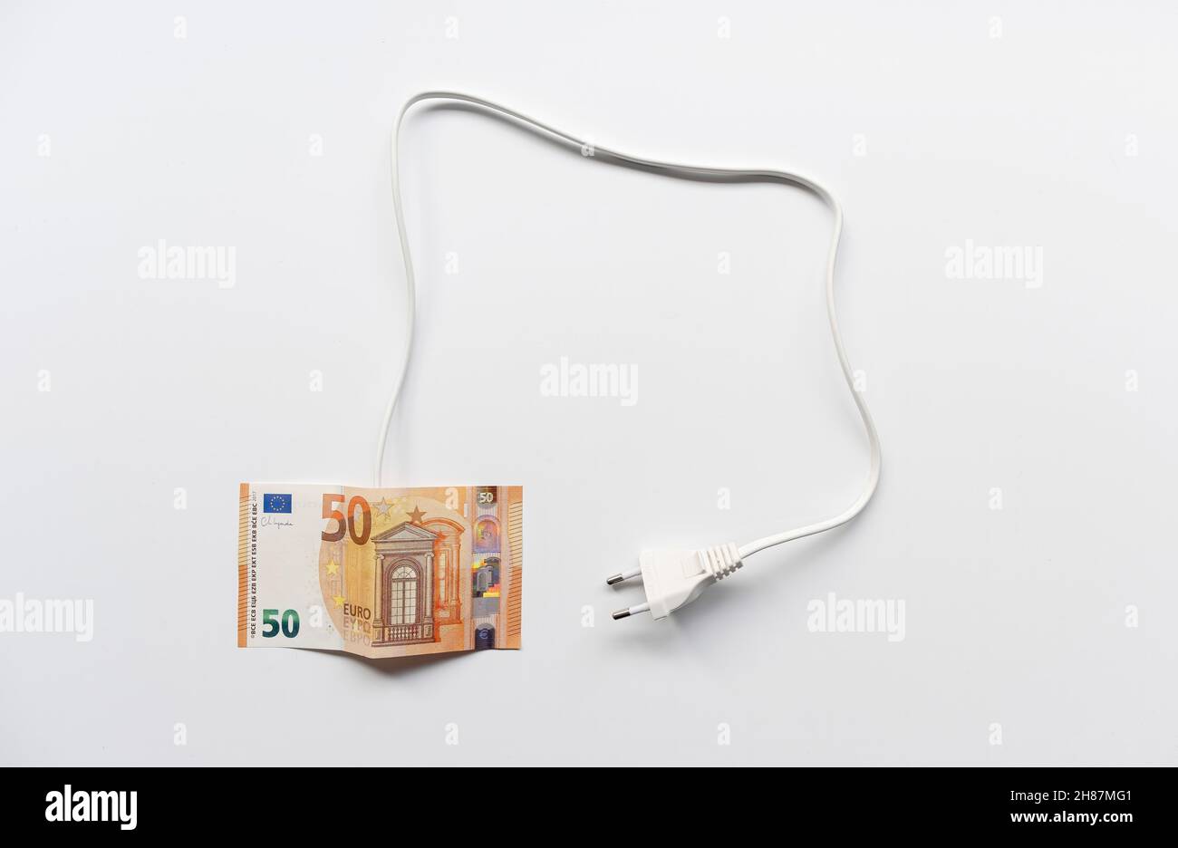Una fattura di cinquanta euro con un cavo e una spina su sfondo bianco, problema di prezzo dell'energia, tariffe elettriche, orizzontale Foto Stock