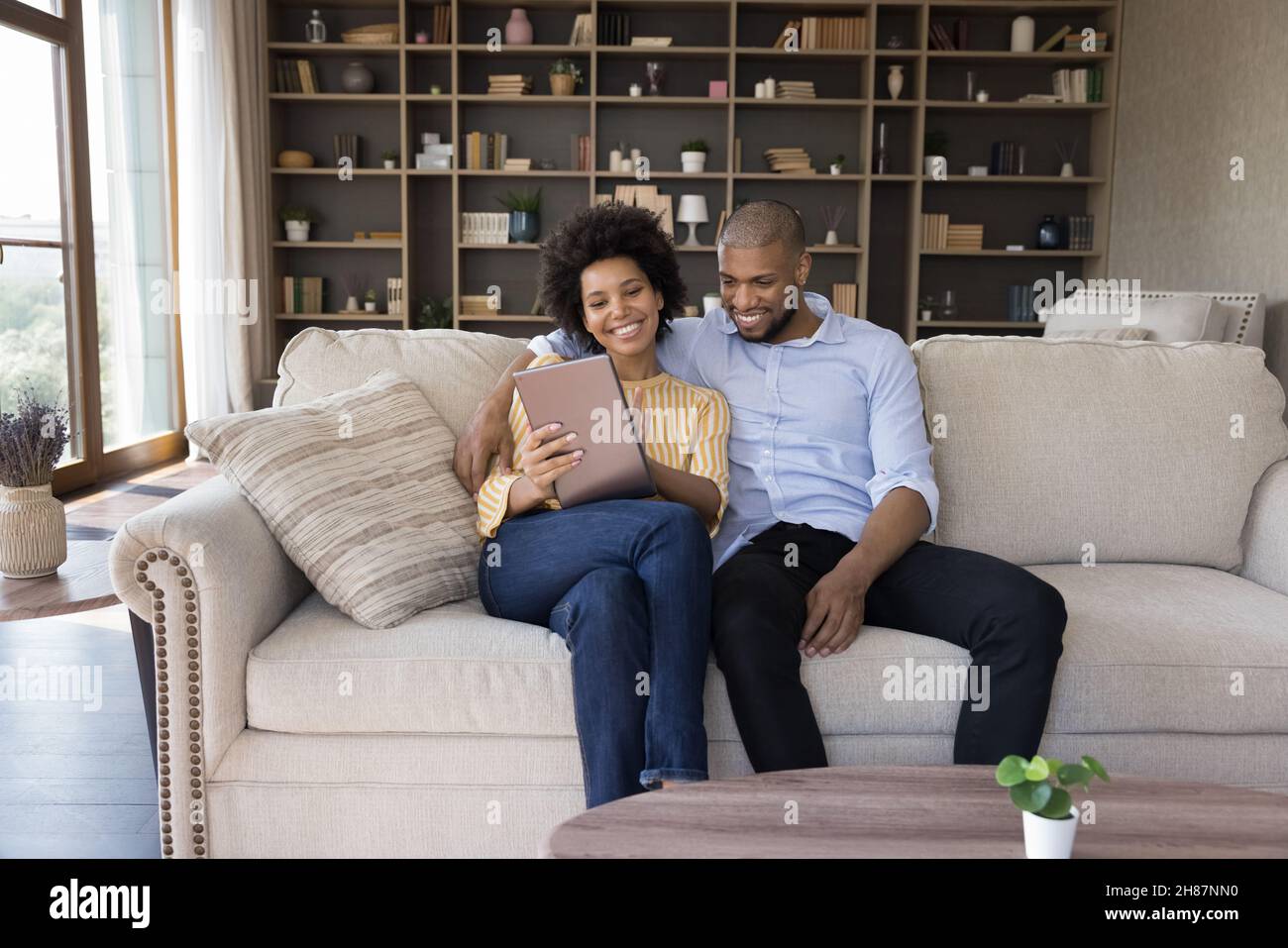 Famiglia giovane felice coppia nera rilassarsi a casa accogliente Foto Stock
