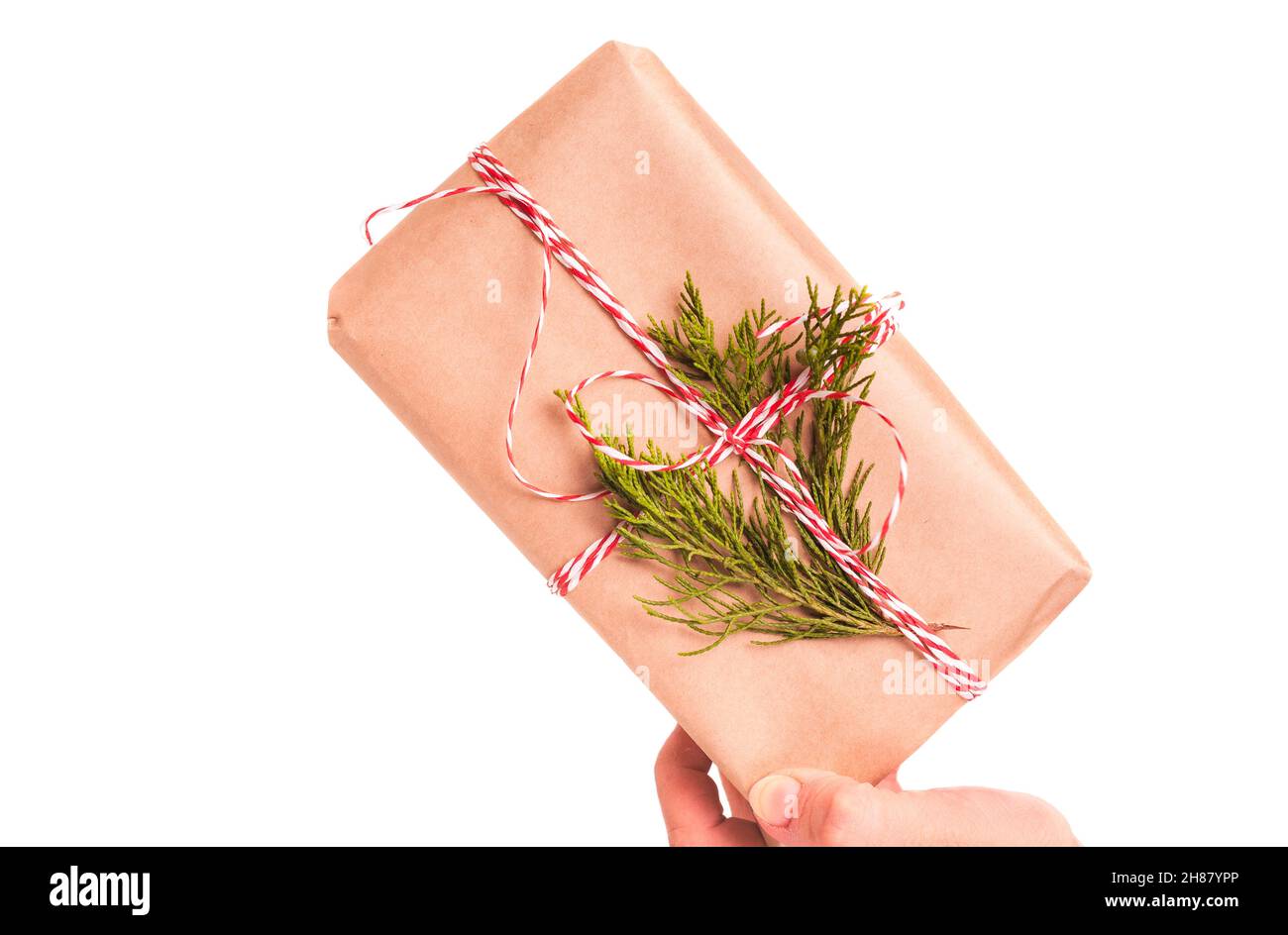 Mano di donne con scatola regalo avvolta in carta artigianale su sfondo bianco Foto Stock