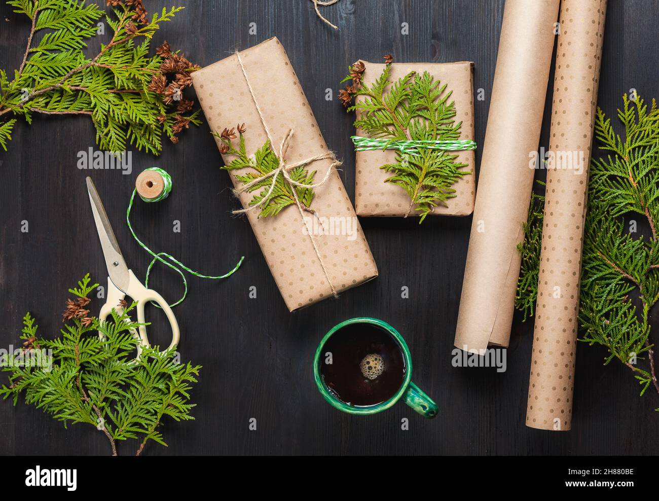 Regali di Natale avvolti in carta artigianale e tazza di caffè nero Foto Stock