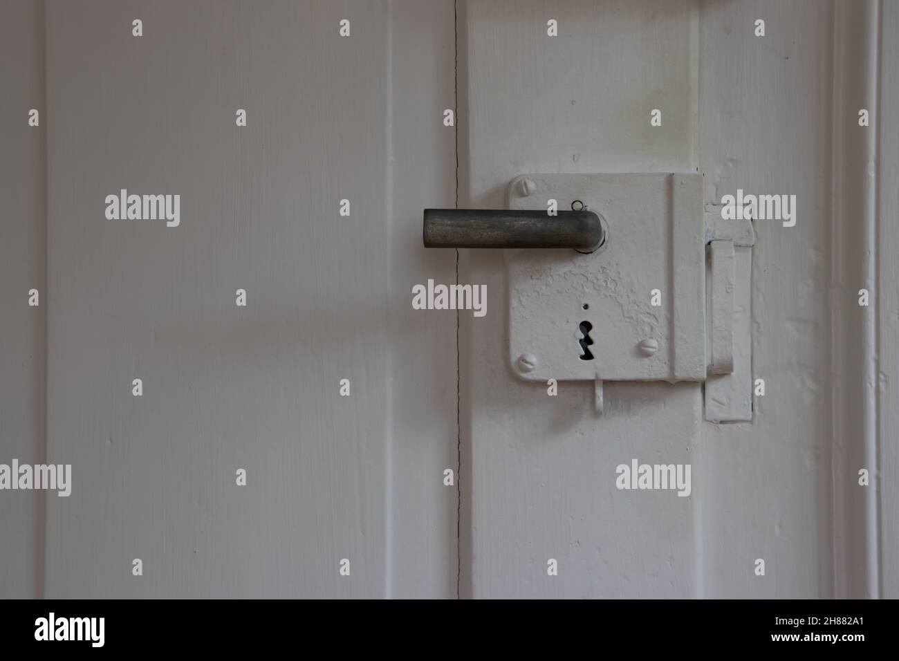 Vecchia cassetta di sicurezza con montaggio a superficie su una vecchia porta di legno dipinta di bianco con spazio per la copia Foto Stock