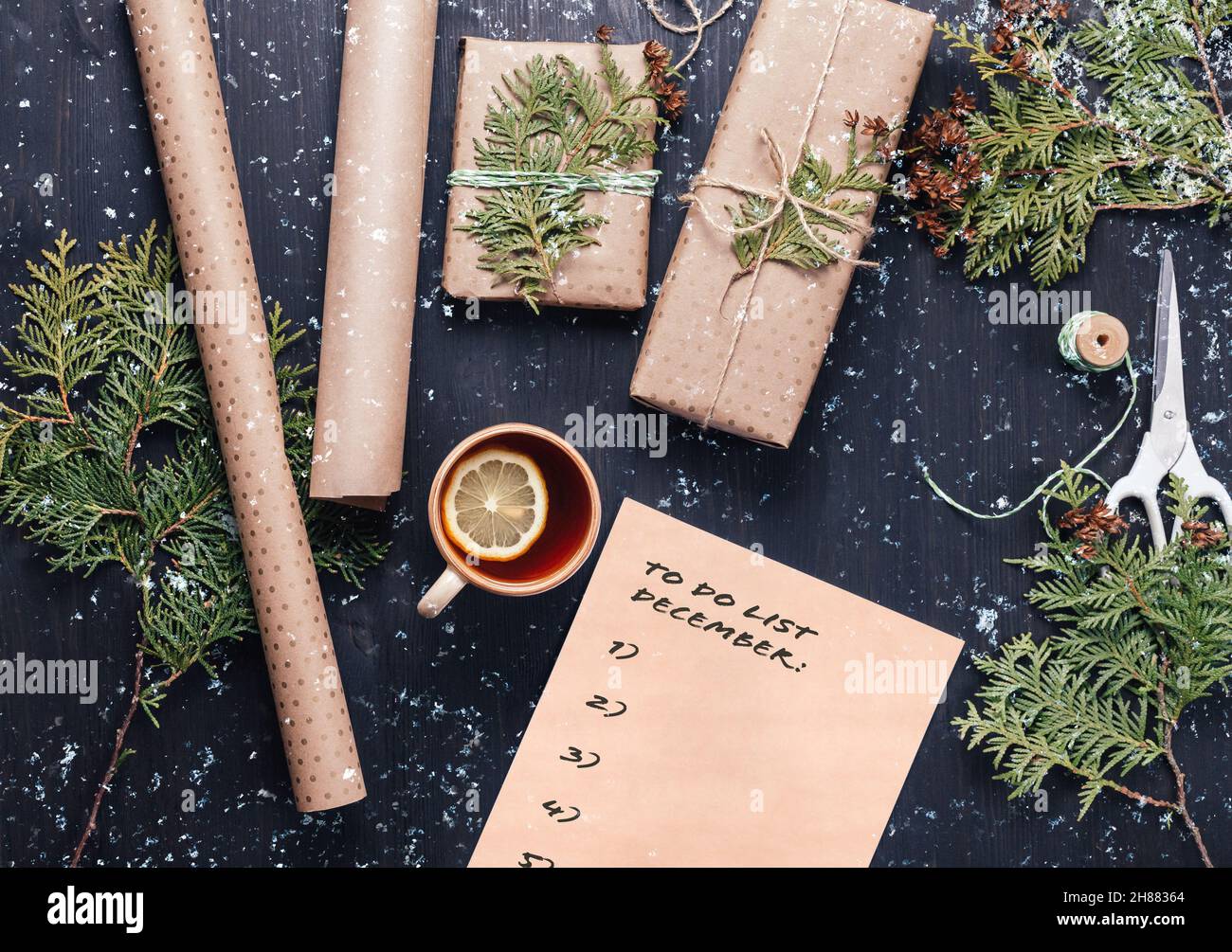 Preparandosi per le feste di Natale. Confezione regalo e scrittura di elenco delle cose da fare Foto Stock