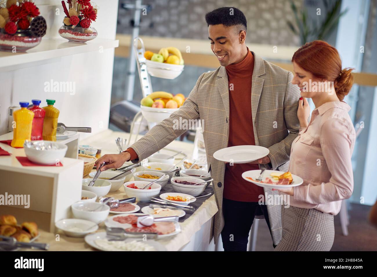Due bei colleghi di lavoro che fanno colazione insieme in ufficio Foto Stock