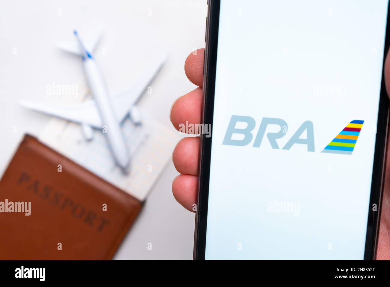 Logo dell'app BRA Airlines sullo schermo del telefono cellulare. Un'immagine sfocata di un aereo, un passaporto e una carta d'imbarco sullo sfondo. Novembre 2021, San Francisco, USA Foto Stock