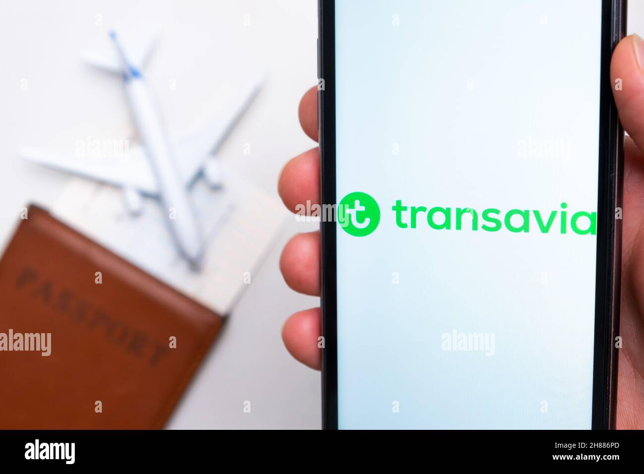 App Transavia Airline sullo schermo di uno smartphone con un aereo e un passaporto sullo sfondo. Il concetto di app di viaggio. Novembre 2021, San Francisco, USA Foto Stock