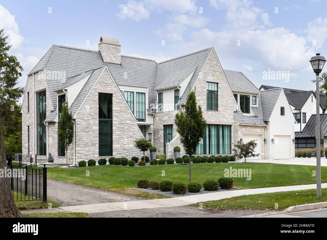Una casa colonica moderna di lusso con una pietra e asse verticale e batten siding, grandi finestre, e bellissimo paesaggio. Foto Stock