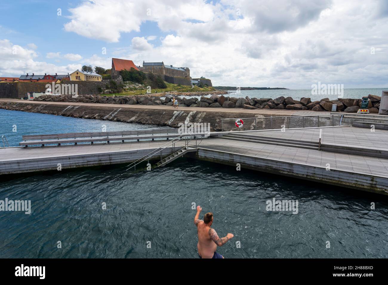 Varberg: Fortezza di Varberg, uomo che salta in piscina d'acqua di mare, area marina Kattegat in , Hallands Län, Svezia Foto Stock