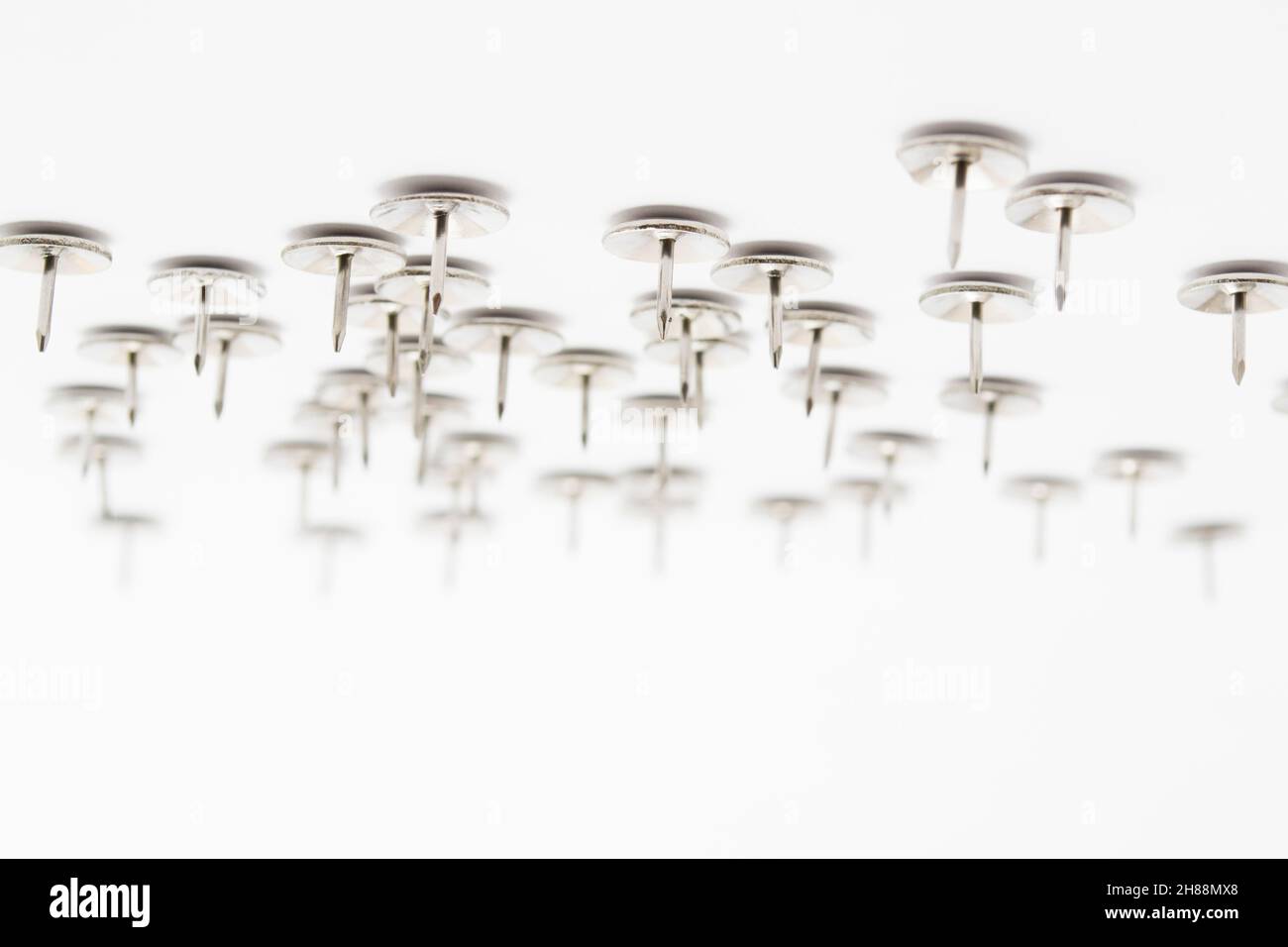 Un mucchio di perno di spinta in metallo o un perno di disegno isolato su bianco Foto Stock