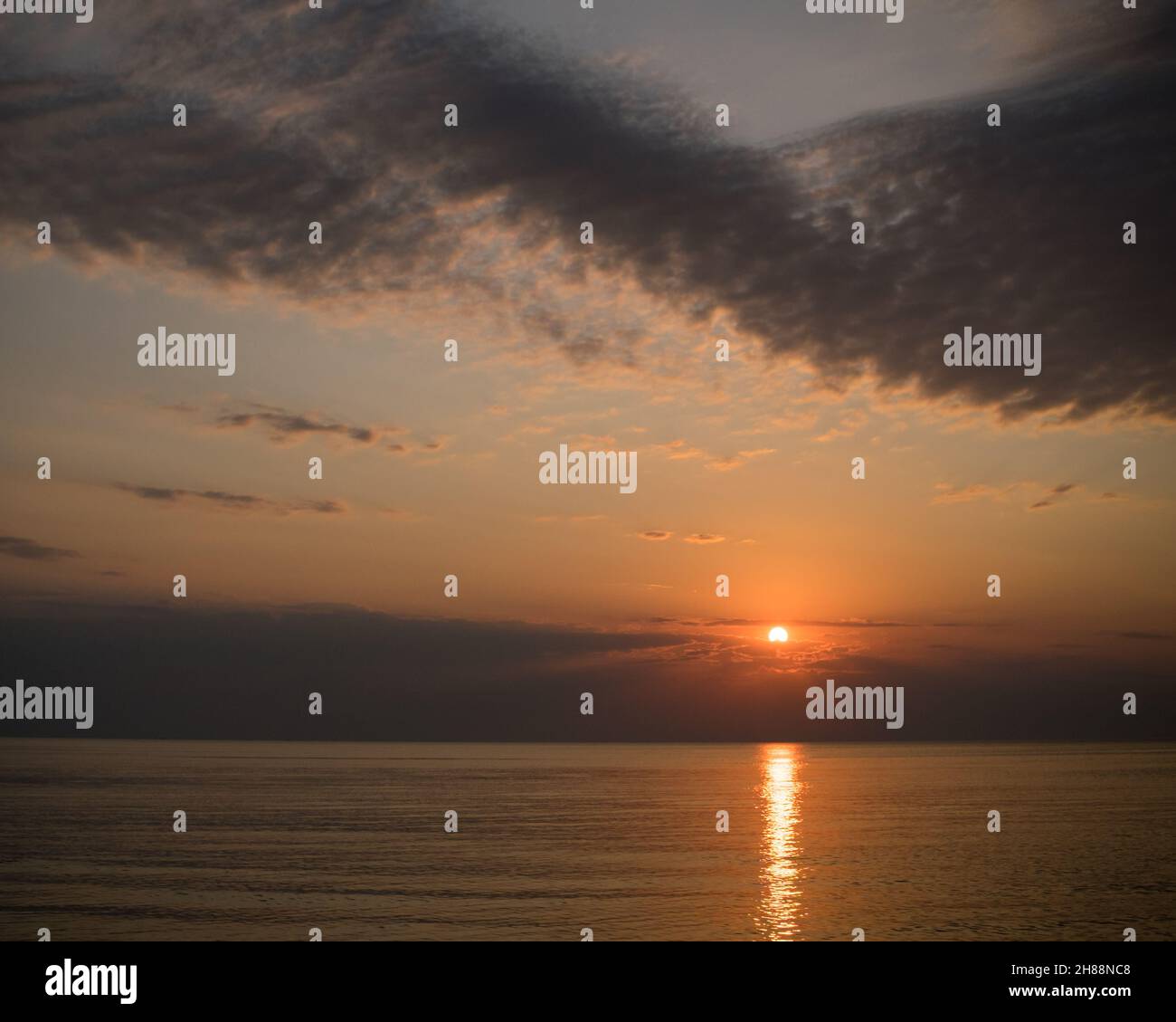Un caldo tramonto sul Mar Baltico con splendide formazioni nuvolose Foto Stock