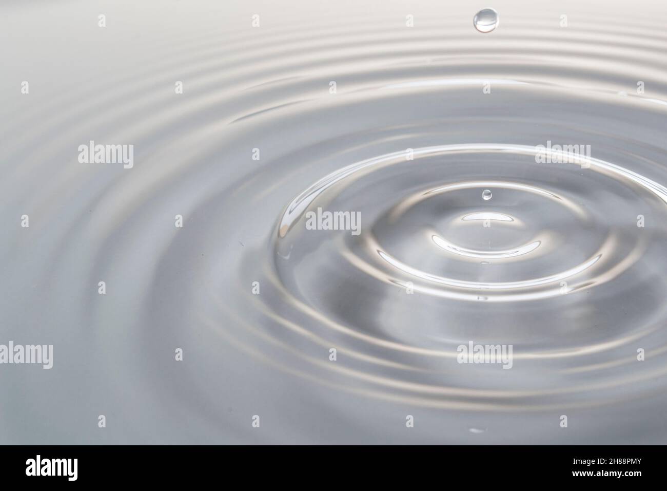 Acqua goccia caduta in acqua facendo una perfetta spruzzi di goccioline Foto Stock