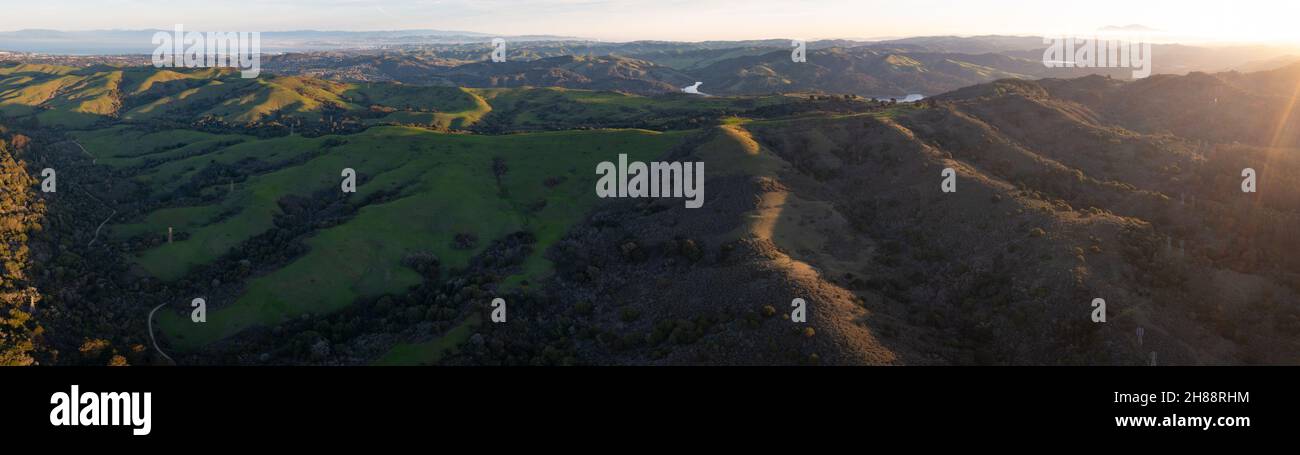 La luce del mattino presto brilla sulle colline ondulate nella regione di East Bay vicino a San Francisco Bay, California. Questa zona diventa verde durante i mesi invernali. Foto Stock