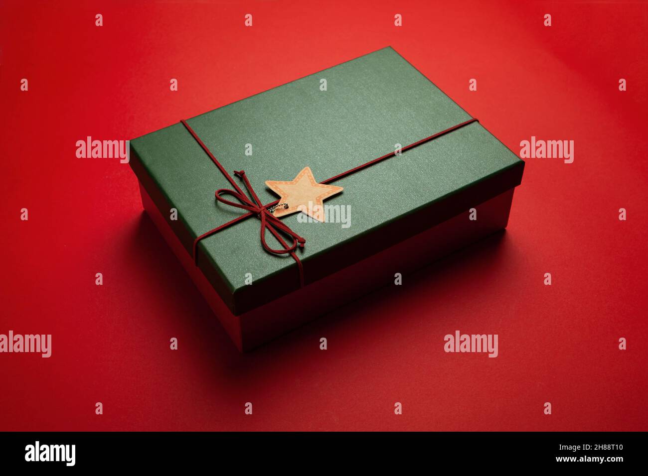 Regalo verde o scatola di Natale su sfondo rosso. Foto Stock