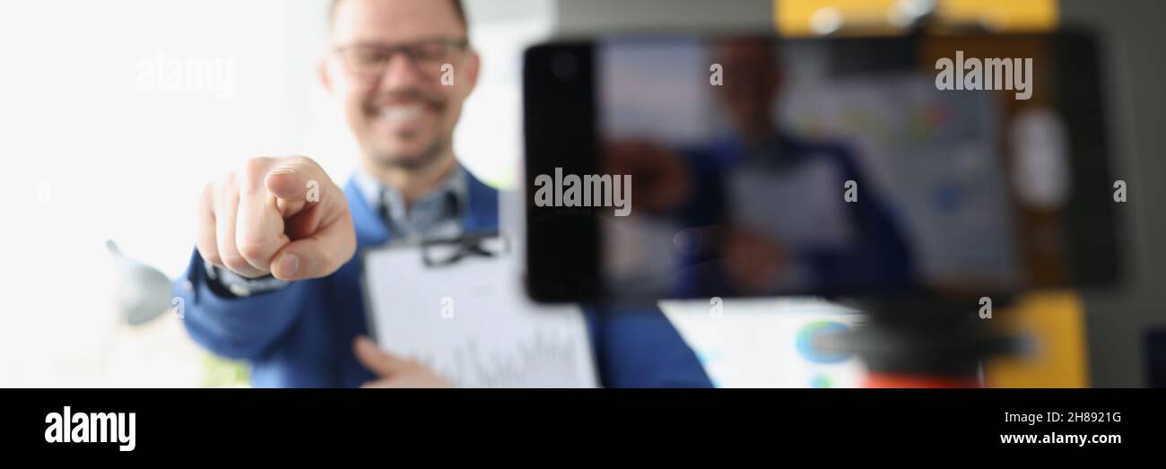Il blogger maschio punta il dito verso il closeup della telecamera Foto Stock