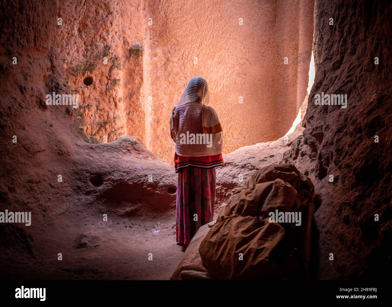 Lalibela, Etiopia - 23 maggio 2021: Una donna velata che indossa abiti tradizionali in una chiesa copta etiope Foto Stock