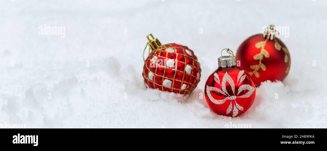 Palline rosse di Natale su sfondo di neve, banner di Natale Foto Stock