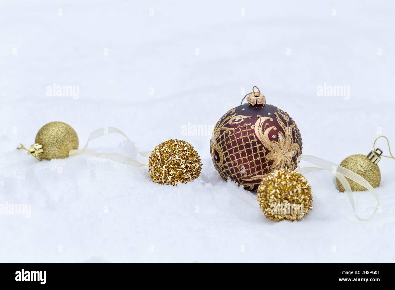 Palle di Natale dorate su sfondo di neve, banner di Natale Foto Stock
