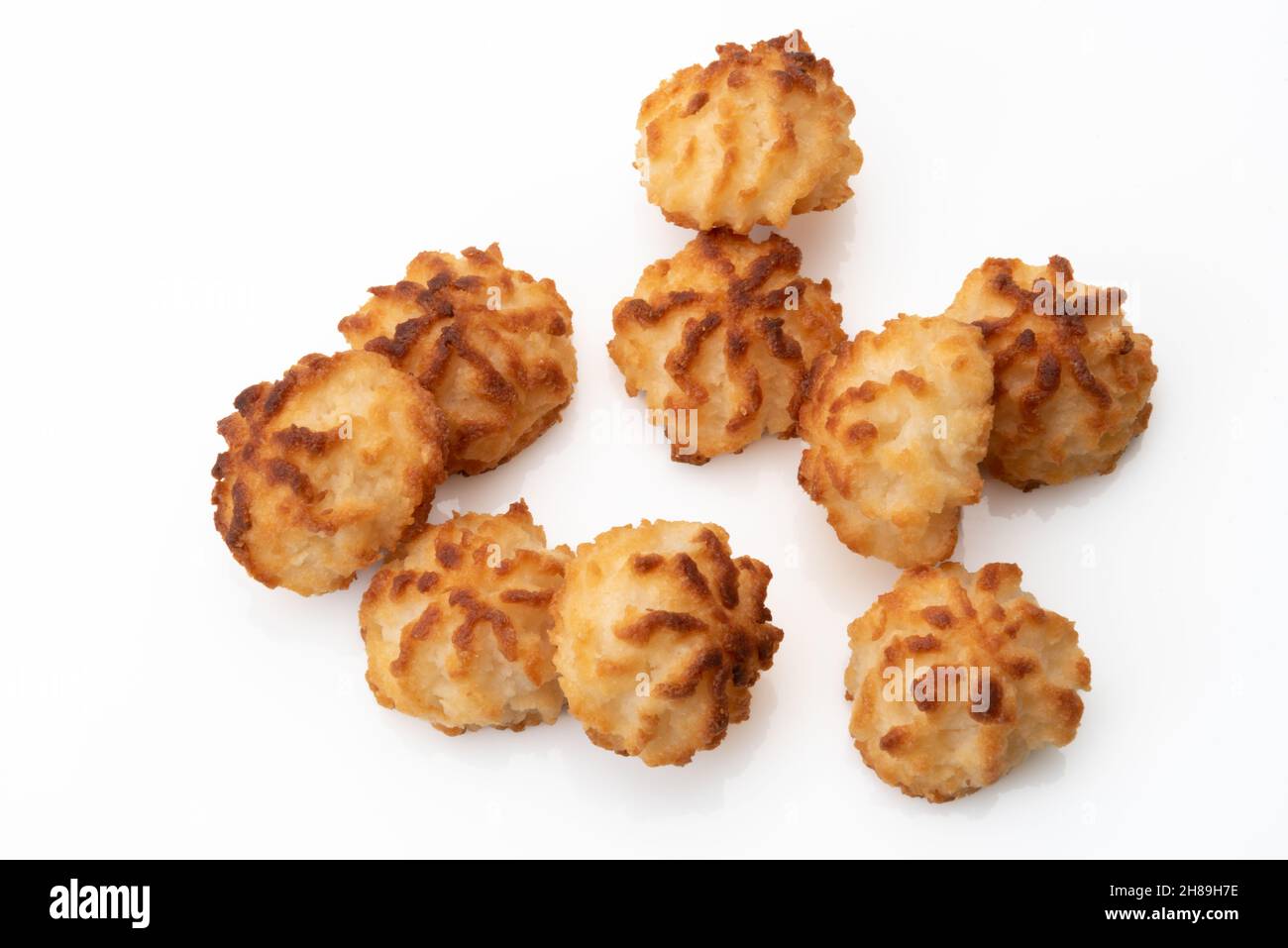 Biscotti di cocco vegani sani fatti con farina di cocco e zucchero, mucchio di biscotto isolato su sfondo bianco, vista dall'alto Foto Stock