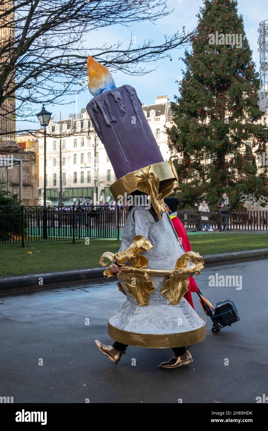 Glasgow, Scozia, Regno Unito. 28 novembre 2021. Un interprete vestito come  Lumière di Disney's Beauty and the Beast si unisce ad altri artisti,  musicisti e ballerini in costume per intrattenere la folla