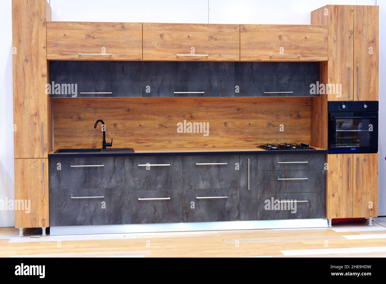 Cucina dal design moderno con dettagli decorativi in legno e faretti interni. Foto Stock