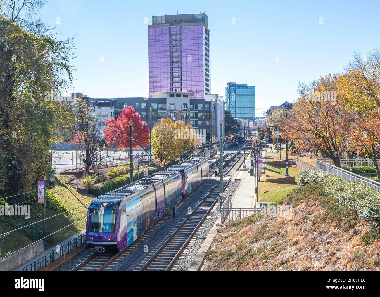 Un treno leggero per pendolari a Charlotte, North Carolina, con il quartiere South End sullo sfondo. Foto Stock